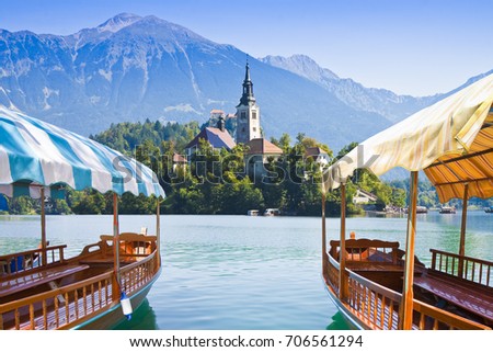 Typical wooden boats, in slovenian call "Pletna", in the Lake Bled, the most famous lake in Slovenia with the island of the church (Europe - Slovenia)  Royalty-Free Stock Photo #706561294