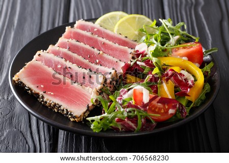 beautiful food: steak tuna in sesame, lime and fresh salad close-up on a plate on the table. horizontal
 Royalty-Free Stock Photo #706568230
