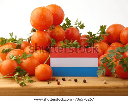 Luxembourg flag on a wooden panel with tomatoes isolated on a white background