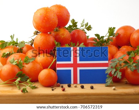 Icelandic flag on a wooden panel with tomatoes isolated on a white background