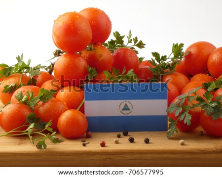 Nicaraguan flag on a wooden panel with tomatoes isolated on a white background
