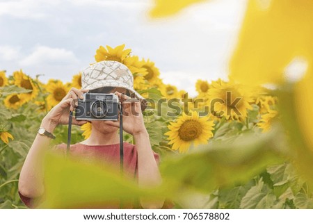 
Young girl holding film camera with beautiful sunflower field background in vacation time ,people with landscape concept