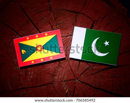 Grenada flag with Pakistan flag on a tree stump isolated