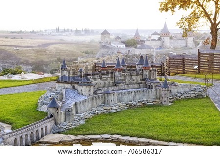 View on  the miniature model of old medieval Kamianets Podilskyi Castle  over the same real castle background, Ukraine
