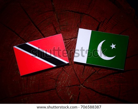 Trinidad and Tobago flag with Pakistan flag on a tree stump isolated