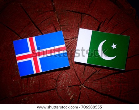 Icelandic flag with Pakistan flag on a tree stump isolated