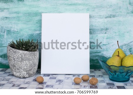 Mock up poster in the interior. Blank canvas, autumn still life with pears and walnuts.