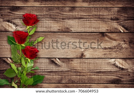 Romantic background with red rose flowers on old brown wood. 
