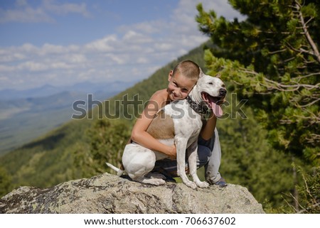 boy with a dog in the mountains on the rocks Royalty-Free Stock Photo #706637602