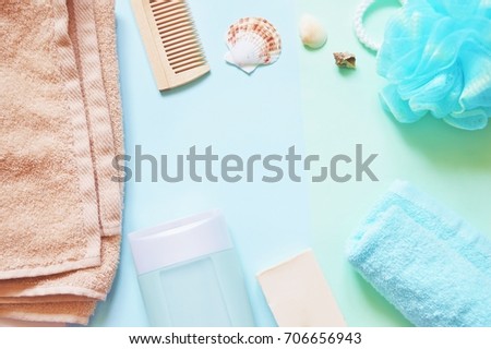 Flat lay bath products. Frame, border for design beauty blog and web site. Terry towel, comb, shampoo bottle, soap and sponge puff on a blue background. Top view stock photo. Shower items