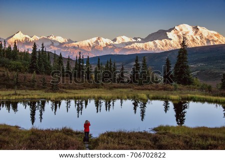 view of alaska's mount denali looms over calm pond at sunset, with clear blue sky above Royalty-Free Stock Photo #706702822