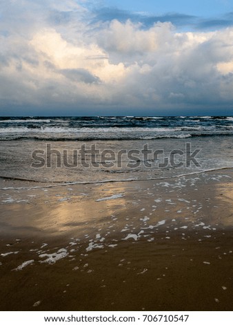 View of a stormy coast beach in the morning. Long exposure shot. Latvia, Liepaja. white waves crushing on to the shore. - vertical, mobile device ready image