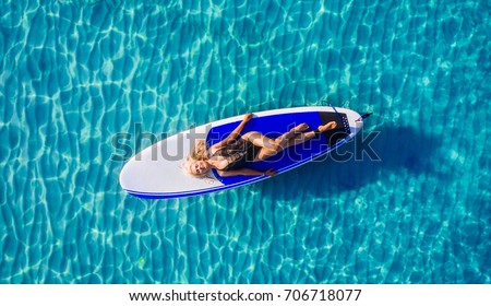 Blonde Woman on Surf Board in Ocean