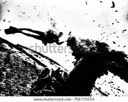 Silhouetted black and white dramatic background. Scuba diver near sunken ship of Thistlegorm in Red Sea near Sharm el Sheikh, Egypt Royalty-Free Stock Photo #706735054