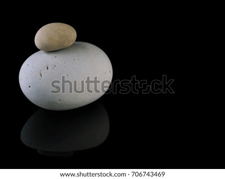 Zen stones rocks spa in stack mindfulness on  black background with reflection. 