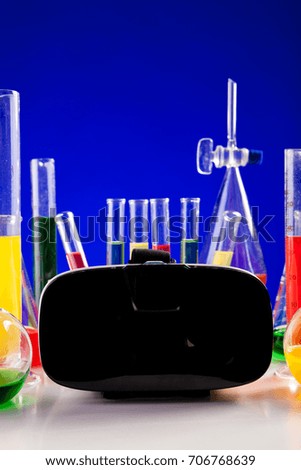 Chemistry lab set on a table with VR headset next to it. Glassware and biology equipment