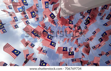 Small size Malaysia flag in tie in large quantities in windy air. 