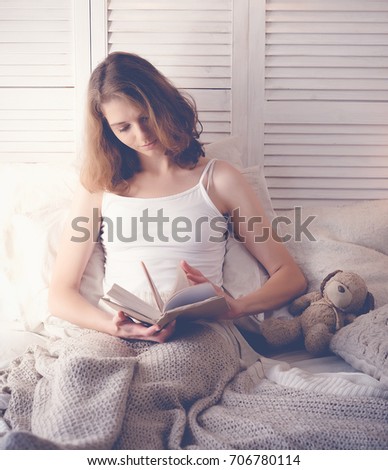 lifestyle and people concept:Young woman lying in bed while read
