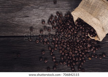 Roasted coffee beans in bag on wood background