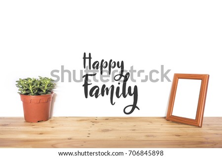Flower vase and photo frame with word "Happy Family" on wooden table for family concept. Isolated white background.