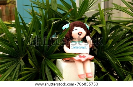 smiling welcome girl clay doll, ceramic  doll, decorated in a garden