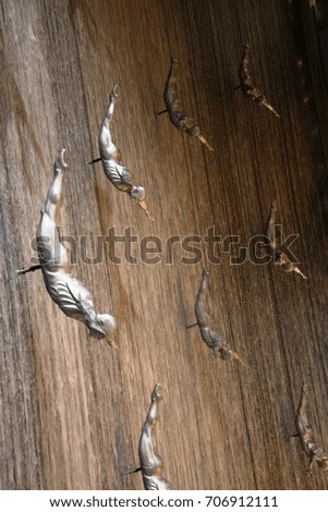Steel men diving, with wooden background
