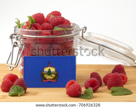Vermont flag on a wooden panel with raspberries isolated on a white background