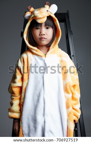 Lovely Asian children, wearing cartoon giraffe clothing, playing in studio