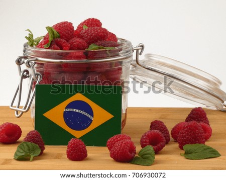 Brazilian flag on a wooden panel with raspberries isolated on a white background