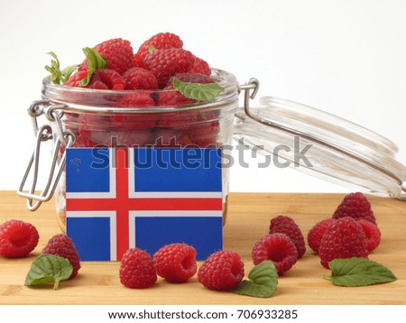 Icelandic flag on a wooden panel with raspberries isolated on a white background