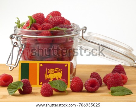 Sri Lankan flag on a wooden panel with raspberries isolated on a white background