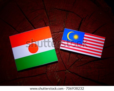 Niger flag with Malaysian flag on a tree stump isolated