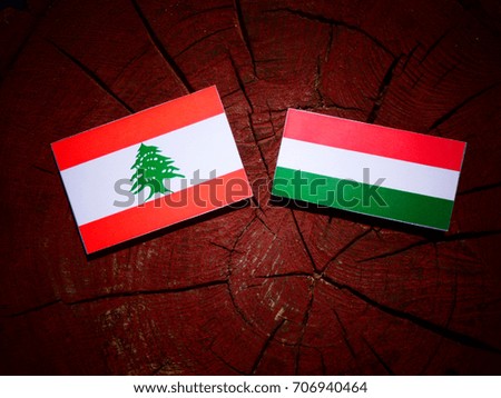 Lebanese flag with Hungarian flag on a tree stump isolated