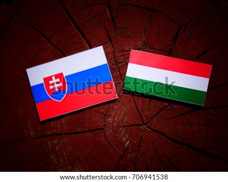 Slovakian flag with Hungarian flag on a tree stump isolated
