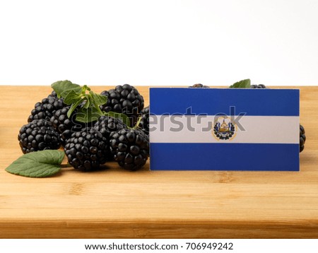 El Salvadoran flag on a wooden panel with blackberries isolated on a white background