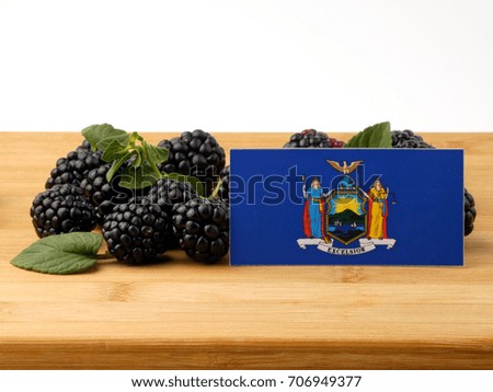 New York flag on a wooden panel with blackberries isolated on a white background