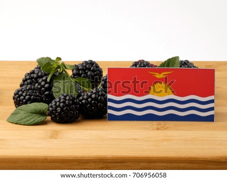 Kiribati flag on a wooden panel with blackberries isolated on a white background