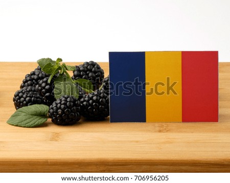 Chad flag on a wooden panel with blackberries isolated on a white background