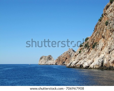 Panoramic picture of high steep cliffs with the ruins of an ancient fortress near the Turkish city of Alanya. View from the sea side