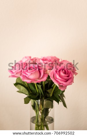 Bouquet of pink roses flowers in glass vase. Vintage natural background with shallow depth of field.