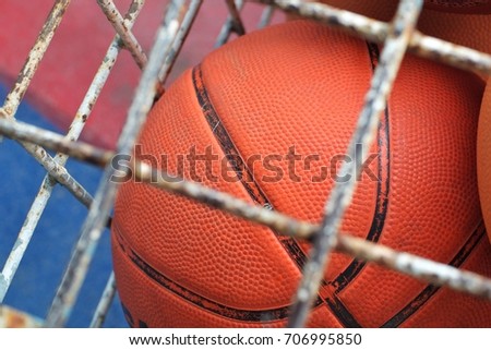 Collection of different balls in a metal cage, school gym