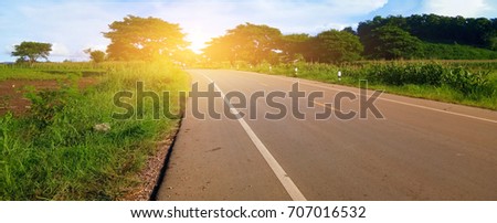Picture of asphalt road with green field and blue sky. landscape scene and sunlight in summer day. Banner for web design. Environment and Nature Concept.
