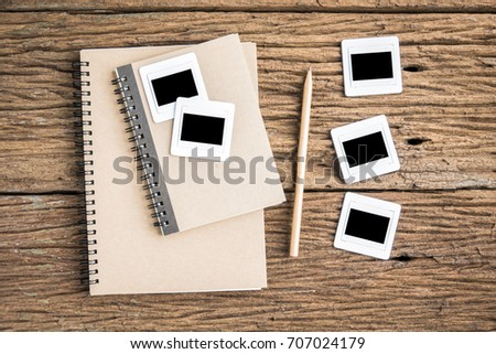 Top view film slide with notebooks on rough wooden background. Film slide 35 mm. 
