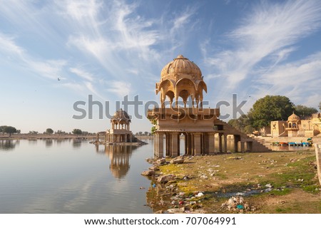 Ornate, intricately carved dome structures of Gadi Sagar Temple, on Gadisar Lake in Jaisalmer, Rajasthan, India.