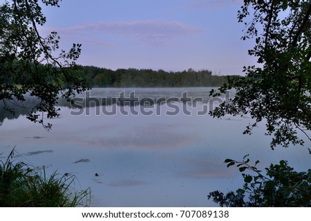 Sunrise. Fog over the lake. The clouds are reflected in the water.Russia. Samara Region.
