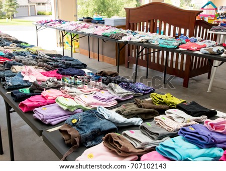 Garage sale tables with clothing Royalty-Free Stock Photo #707102143
