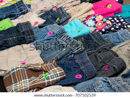 Children's pants on display at a suburban garage sale Royalty-Free Stock Photo #707102539