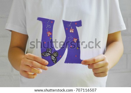 Child holding letter U from the alphabet on a white background