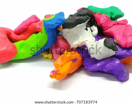 multicolored plasticine (clay)mixed together in a strange shapes on a white background