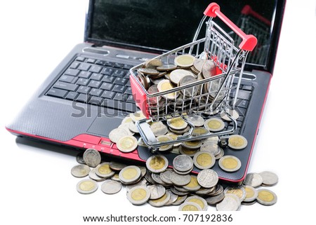 Shopping trolley or cart with coin on laptop or notebook for E-commerce concept or finance concept on white background or isolated